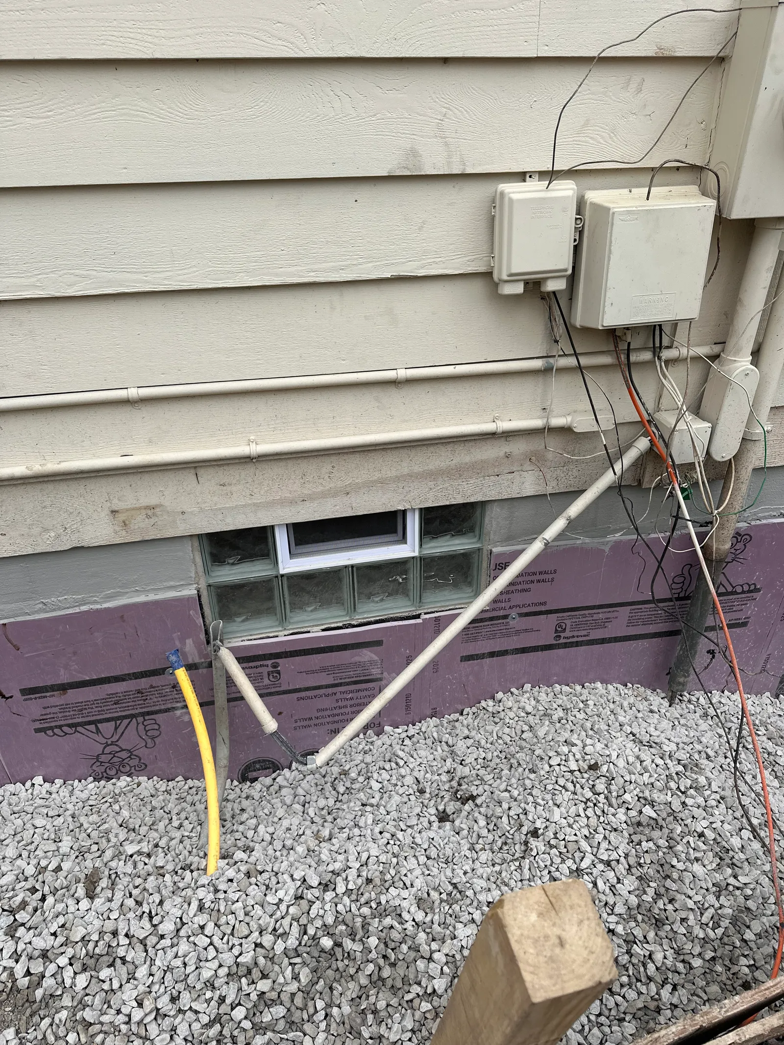Rigid foam insulation board with gravel backfill on waterproofed foundation