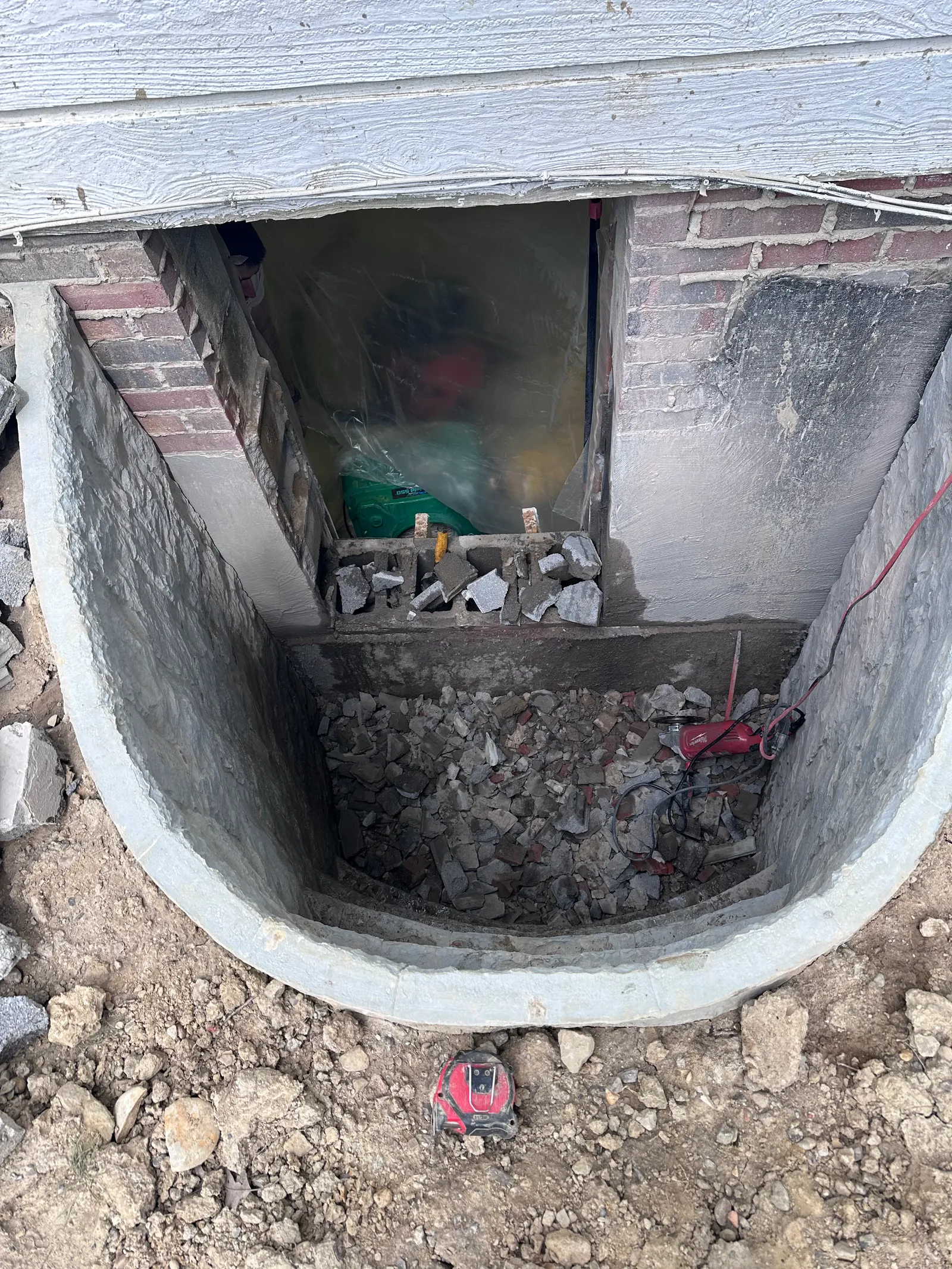 Window well filled with rubble drainage material during installation