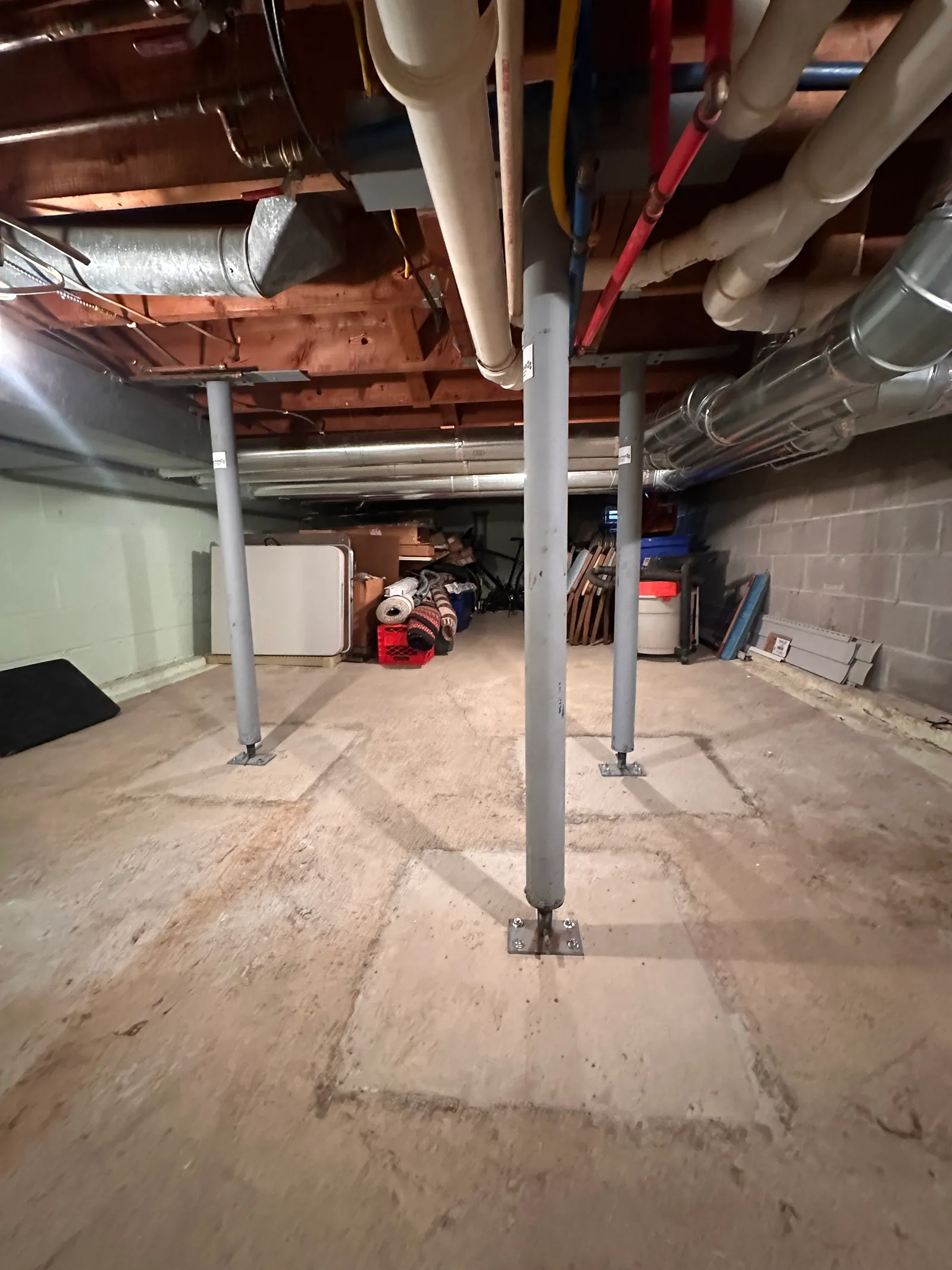 Completed basement beam installation with support columns and utilities