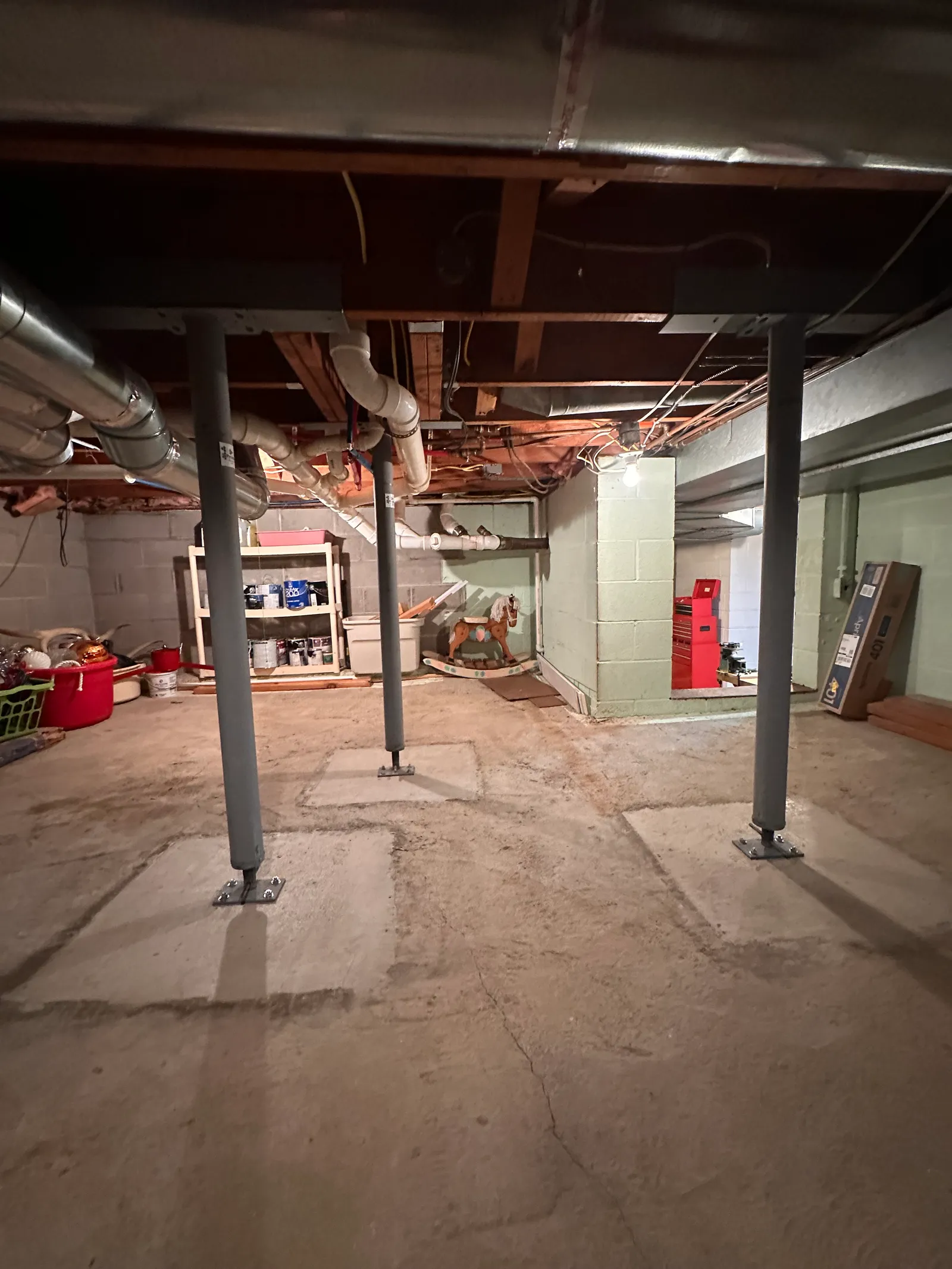 Completed steel I-beam supported by three lally columns in basement