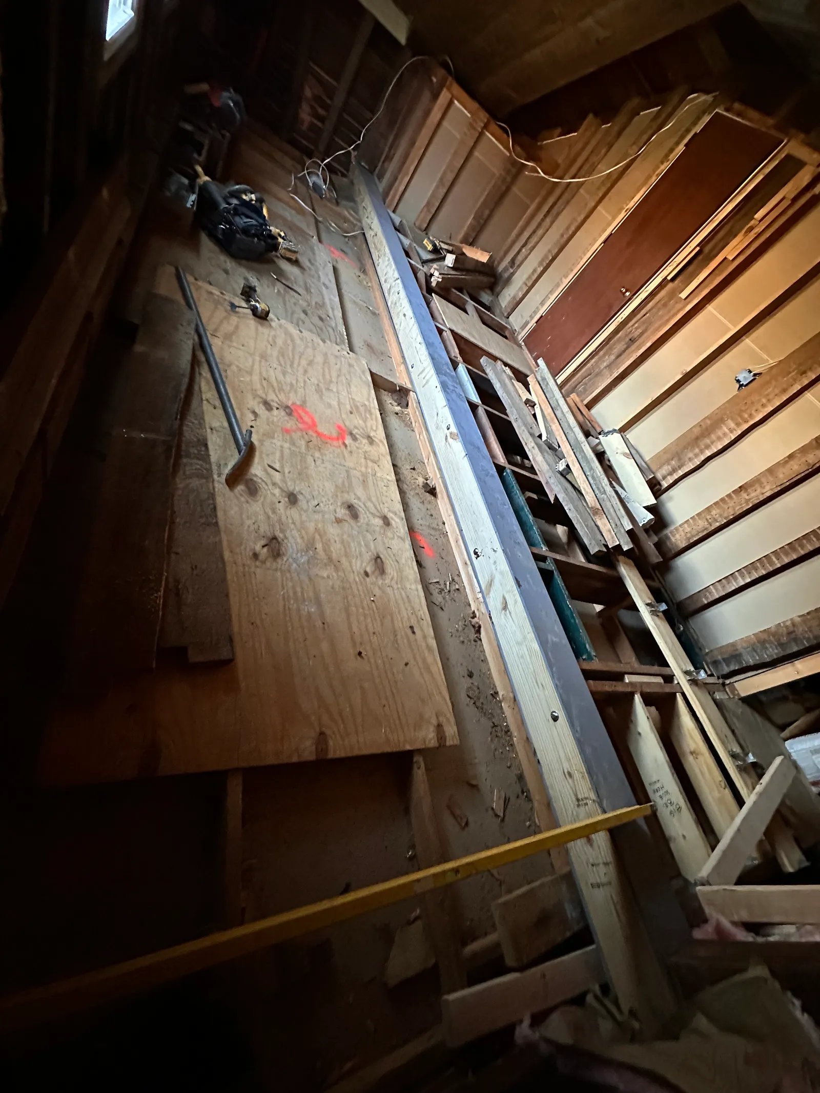 Steel beam extending through floor cavity with staircase in background