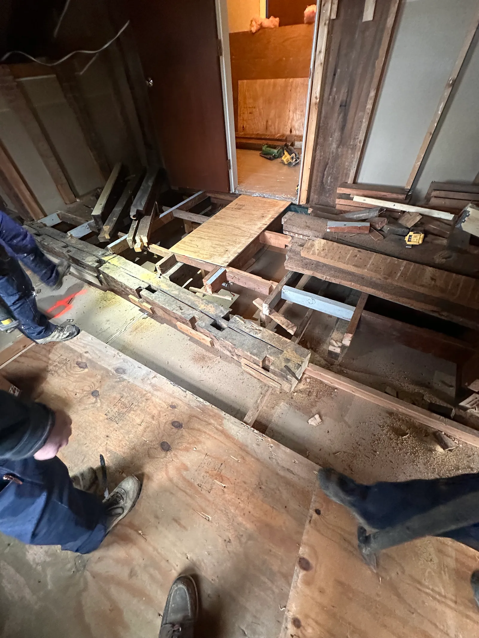 Steel I-beam being positioned within open floor cavity for structural support