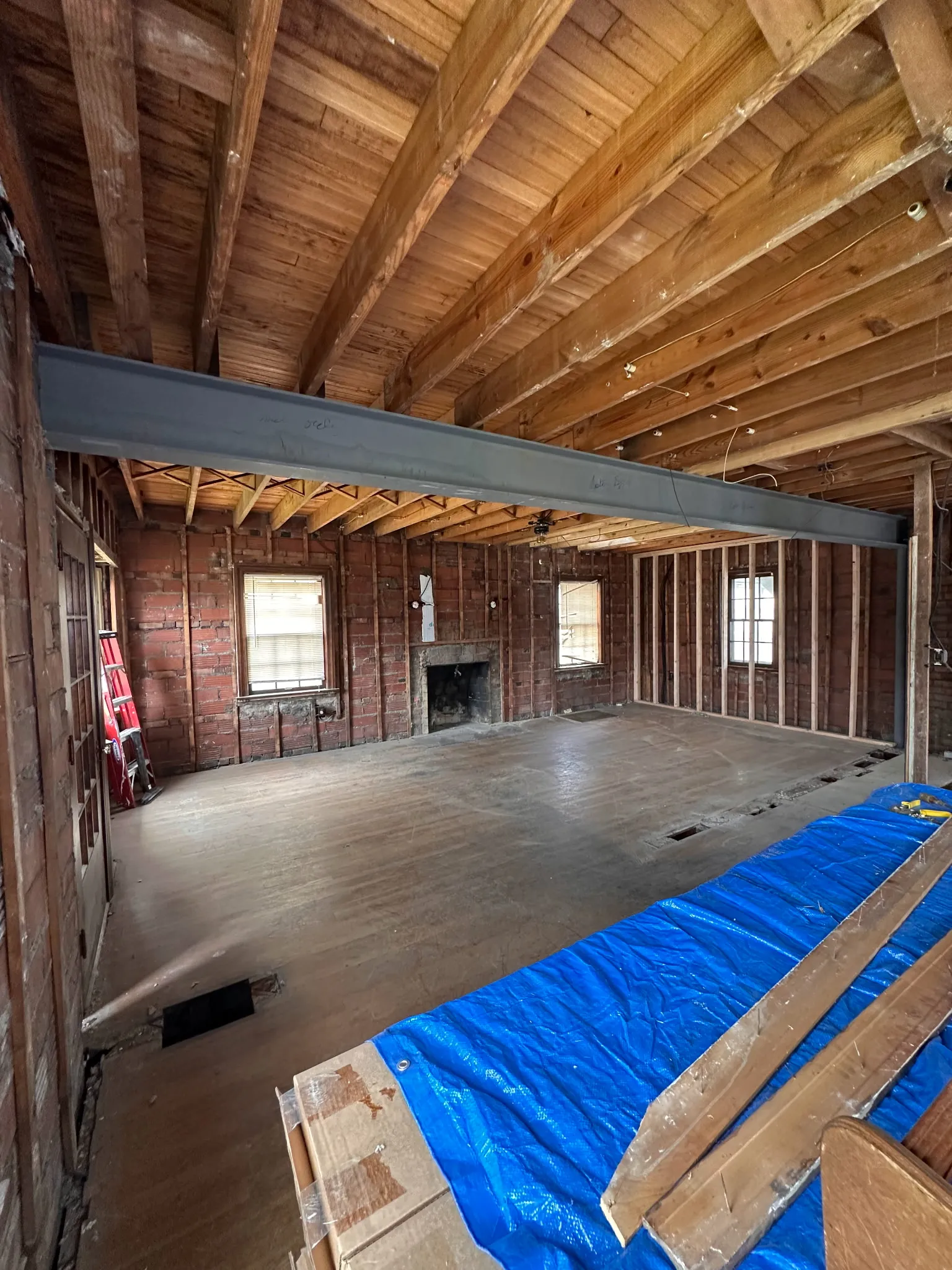 Large open room with new steel beam spanning across exposed brick walls