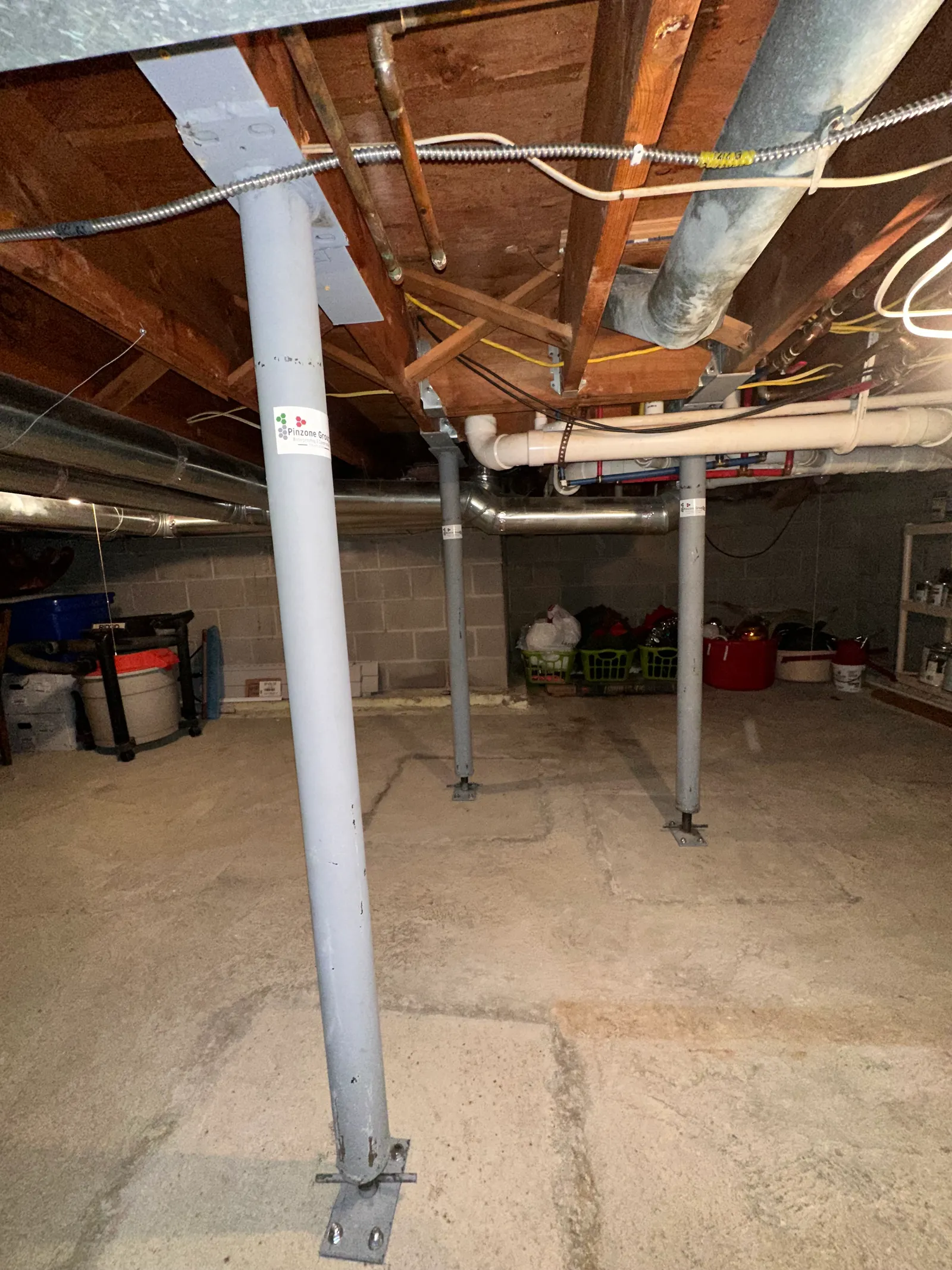 Multiple steel adjustable lally columns anchored to basement floor