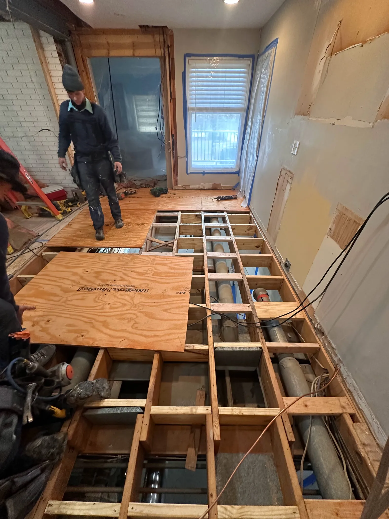 Subfloor and joist repair with new plywood installed over exposed floor joists
