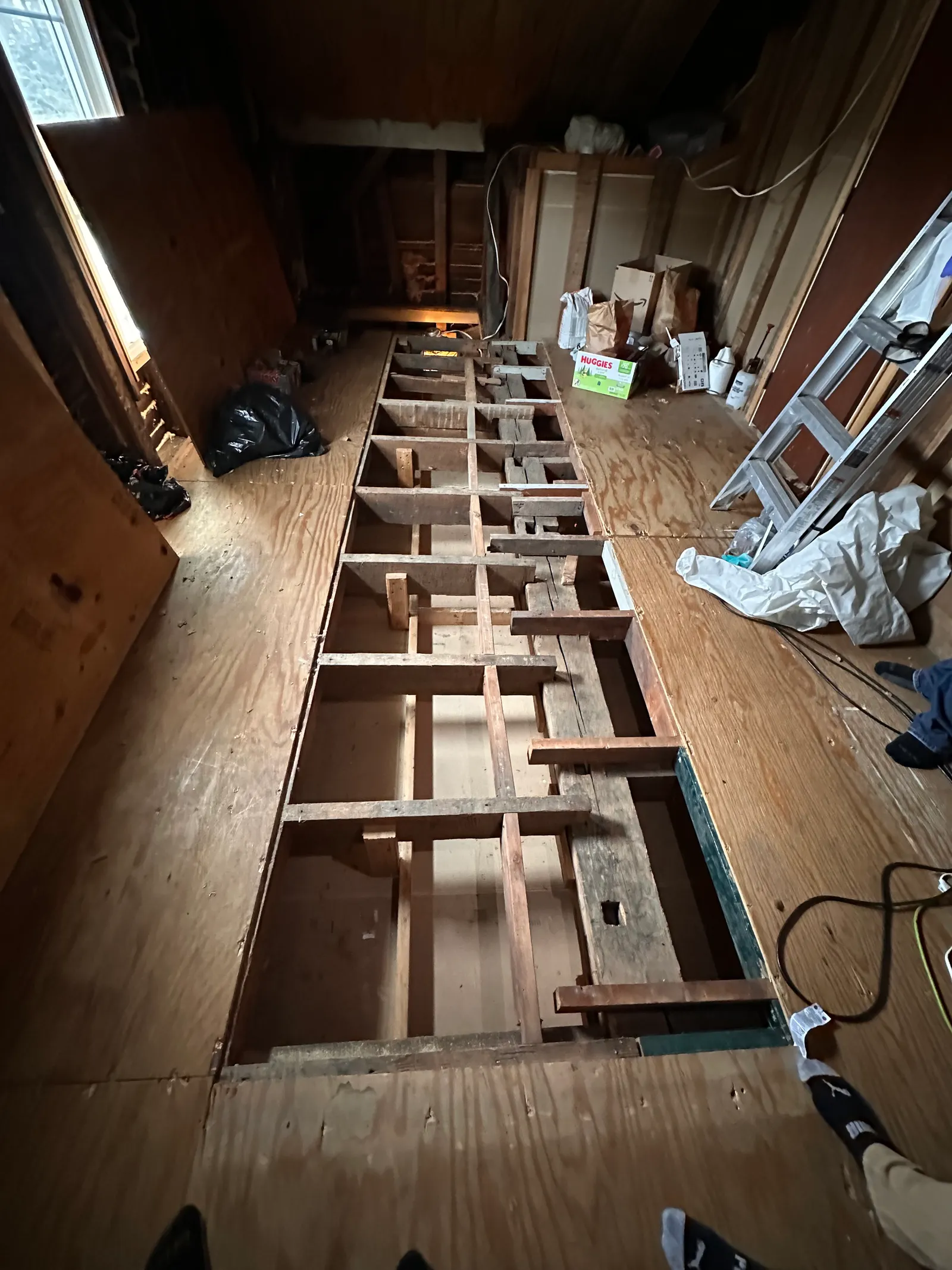 Subfloor cut open to expose floor joists for repair and assessment