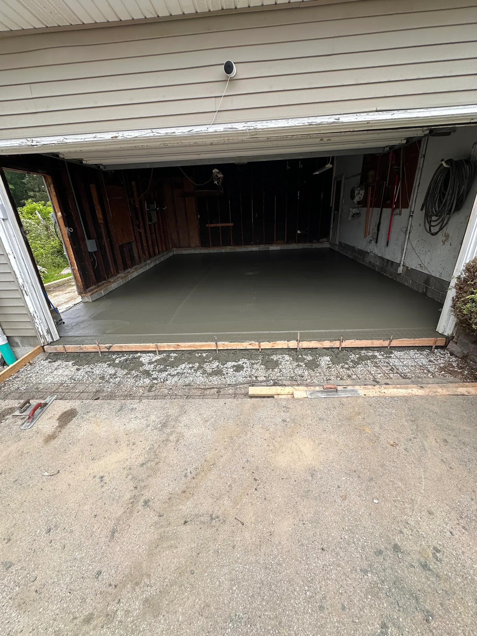 Fresh concrete poured for garage slab with wood forms in place