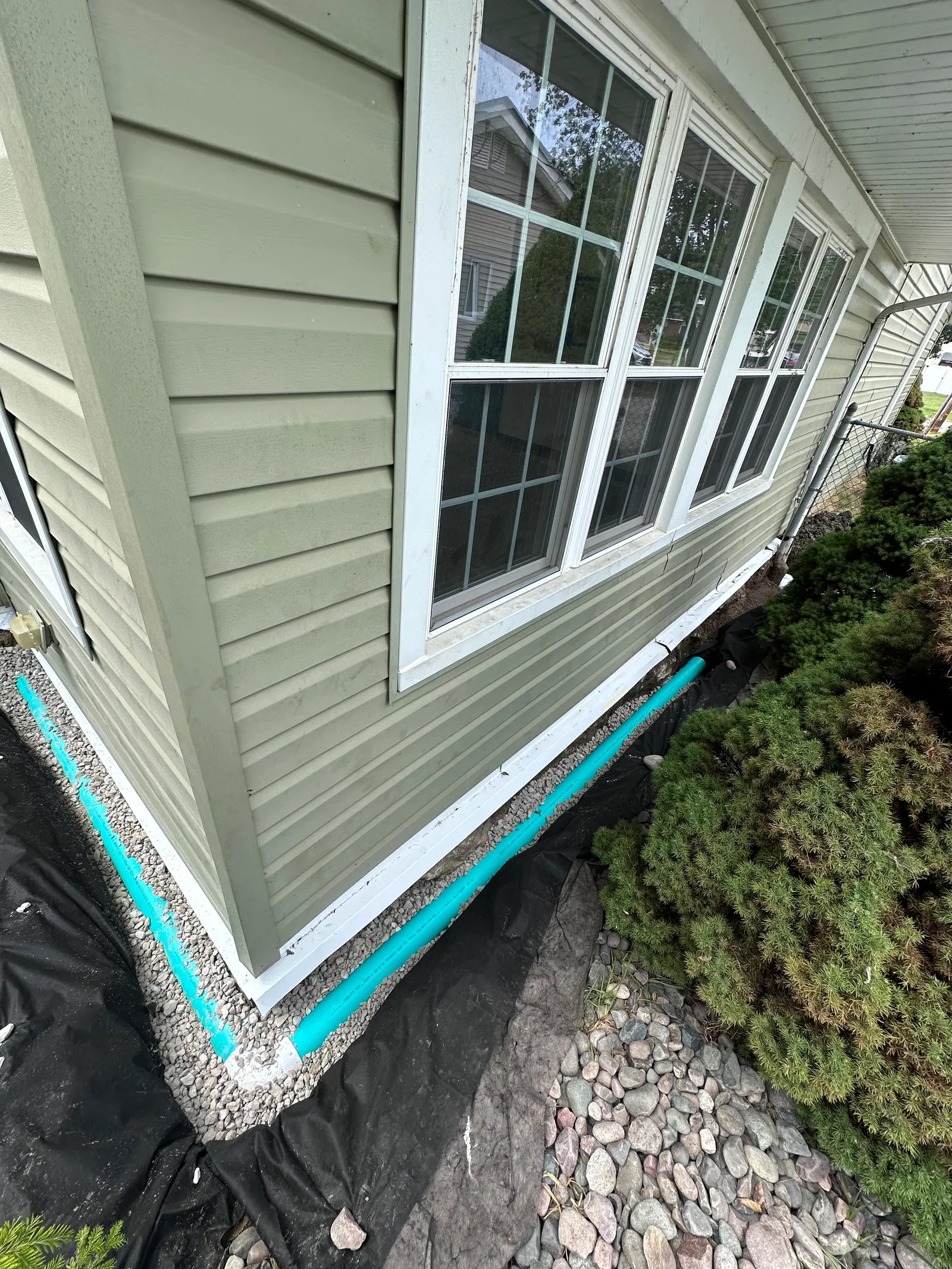 Finished perimeter drainage system with landscaping on residential property