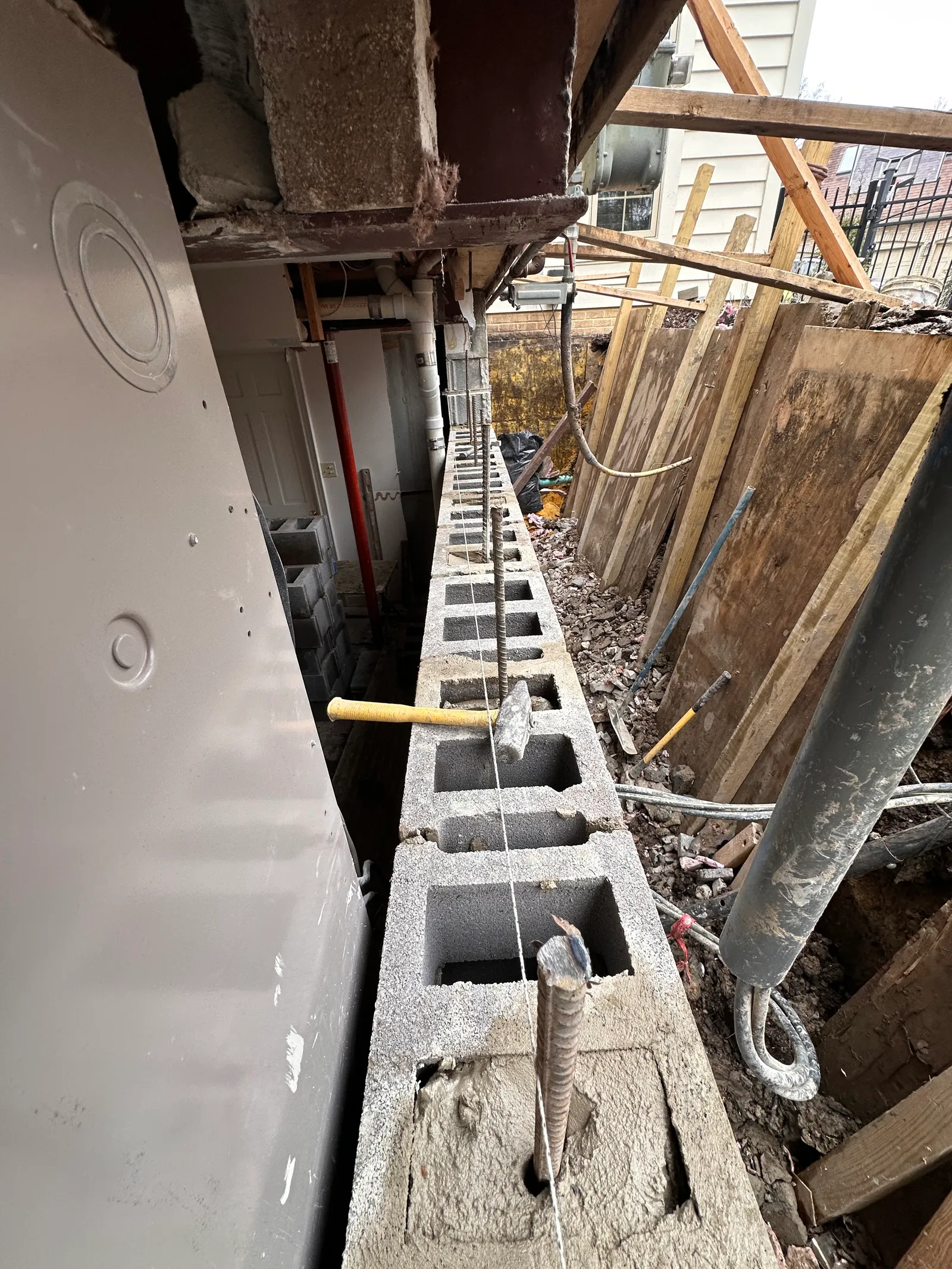 CMU block wall opened with rebar reinforcement protruding during reconstruction