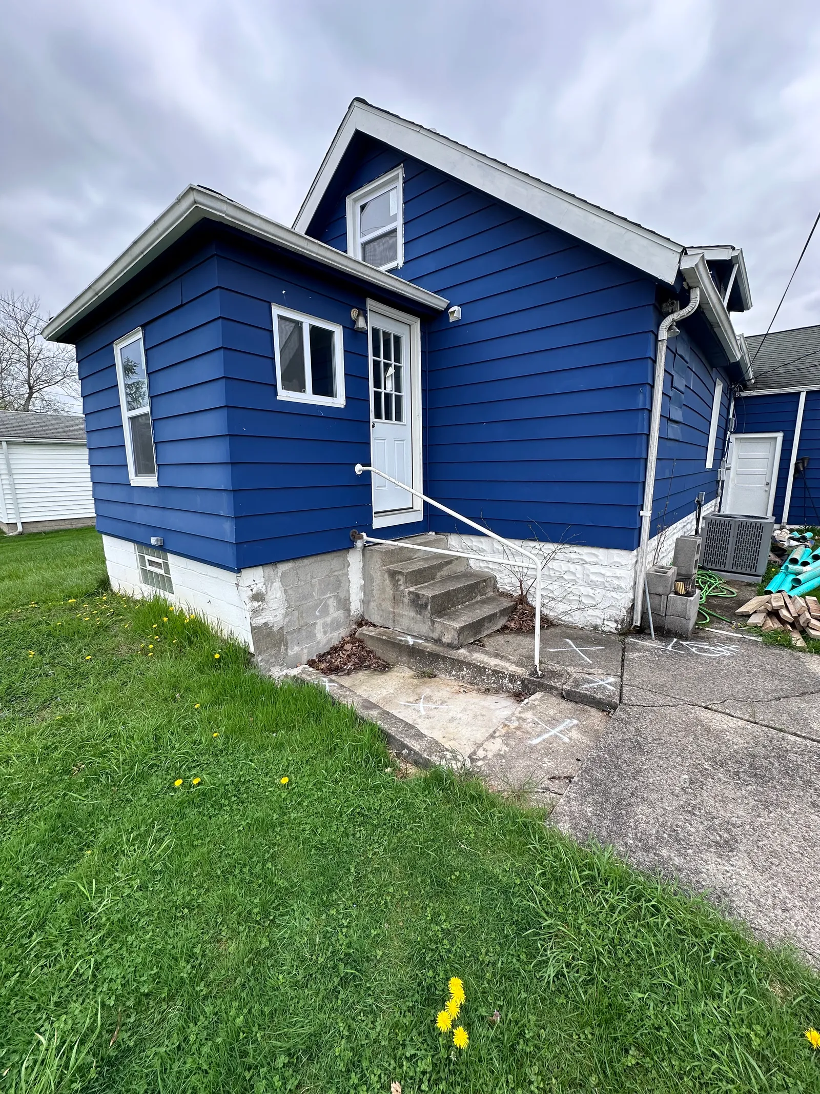 Side view of Cleveland bungalow showing exposed foundation wall during repair