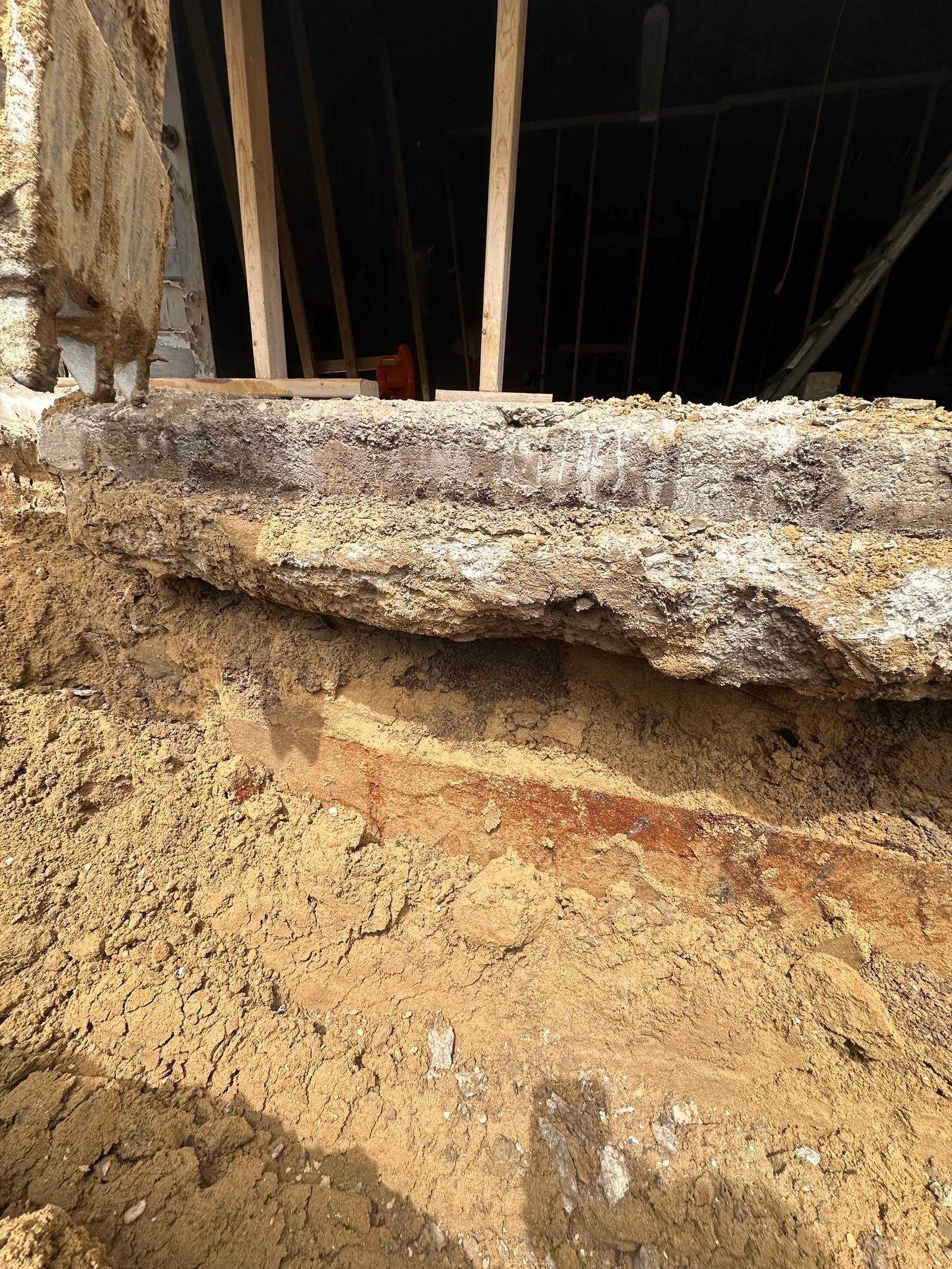 Close-up of exposed foundation wall showing efflorescence and deterioration