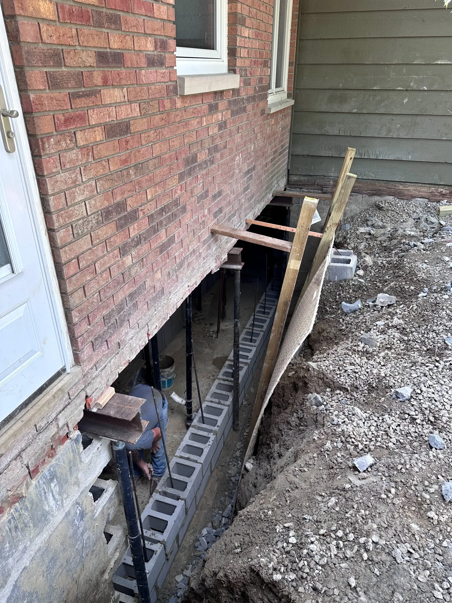 Exterior foundation wall repair with cinder block reinforcement on a Cleveland home