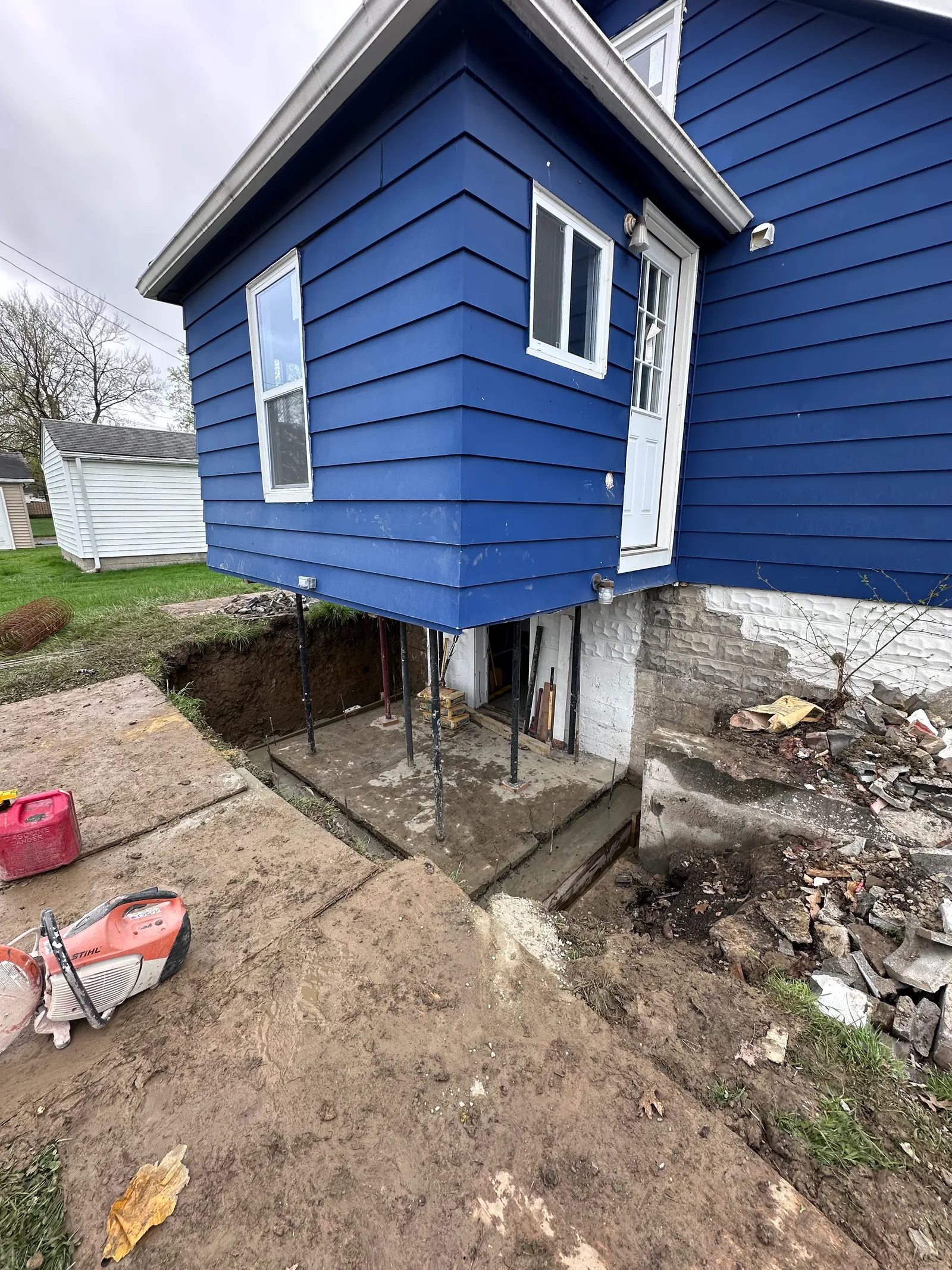 Deep exterior excavation along residential foundation exposing footing in Cleveland
