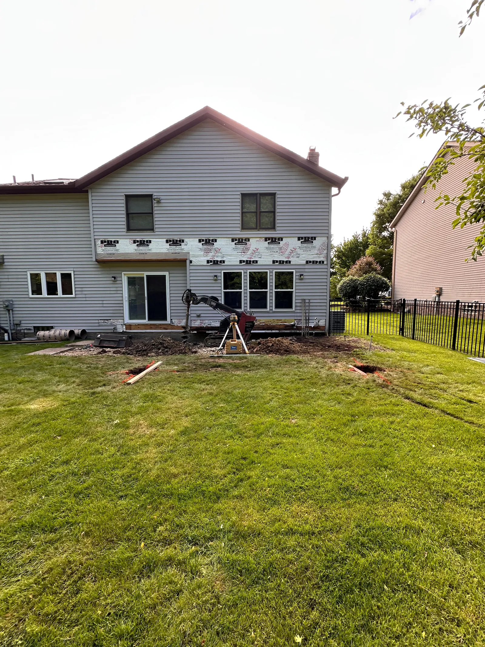 Residential home under renovation with foundation and siding work in progress