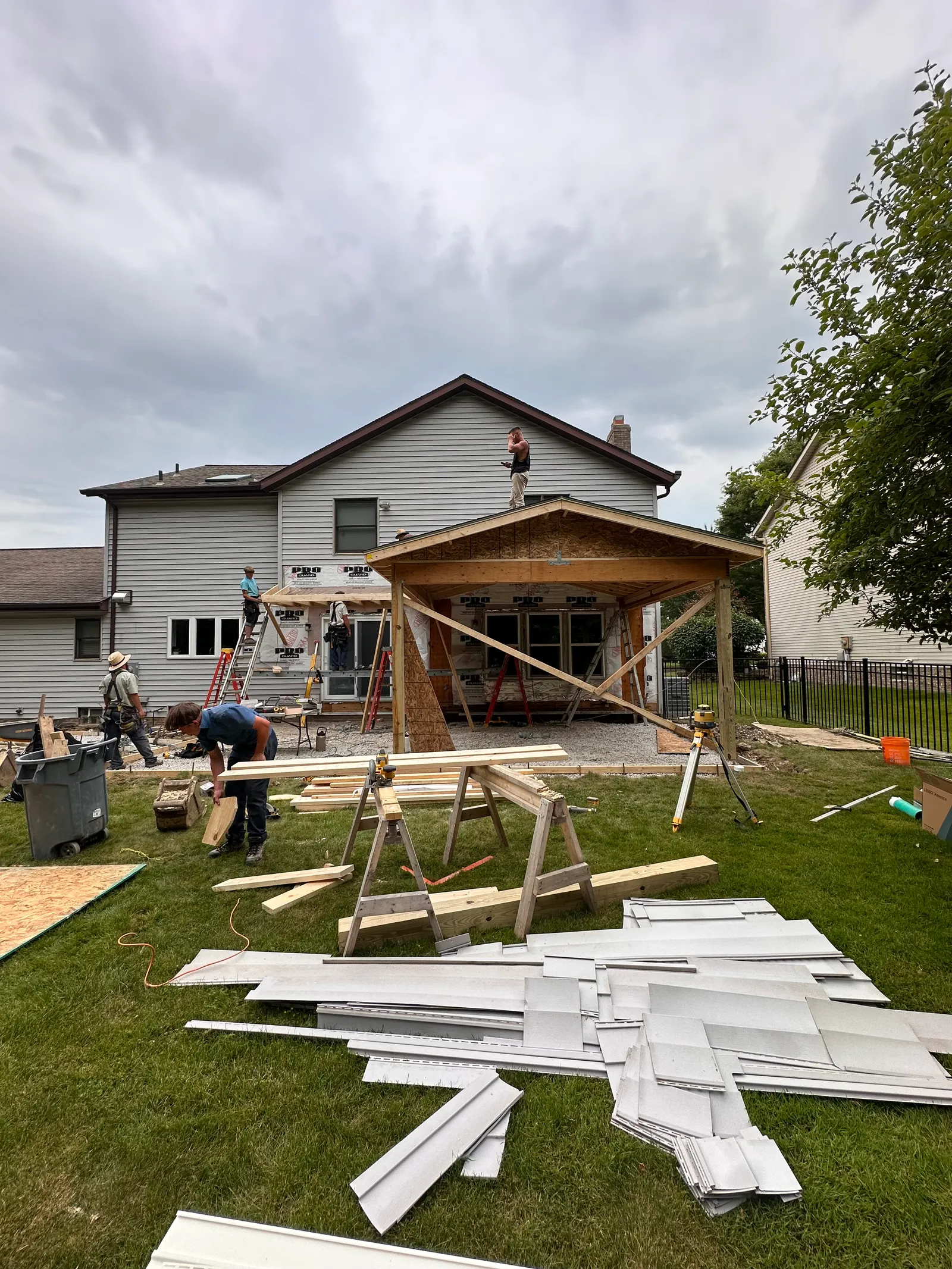 Crew framing a covered porch and structural addition on residential home