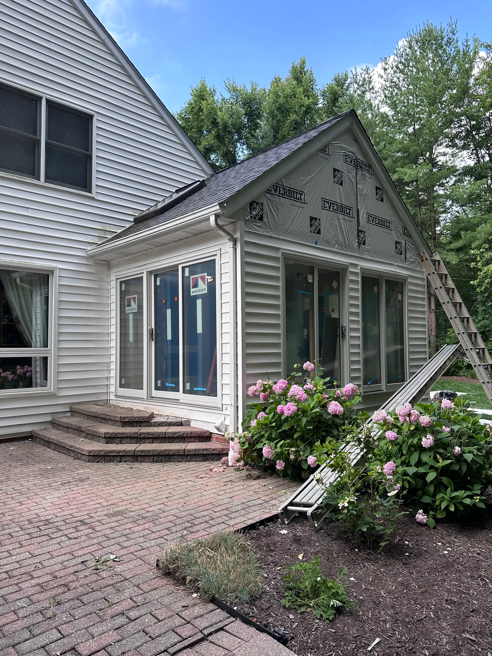 Front view of home with siding in progress during structural renovation