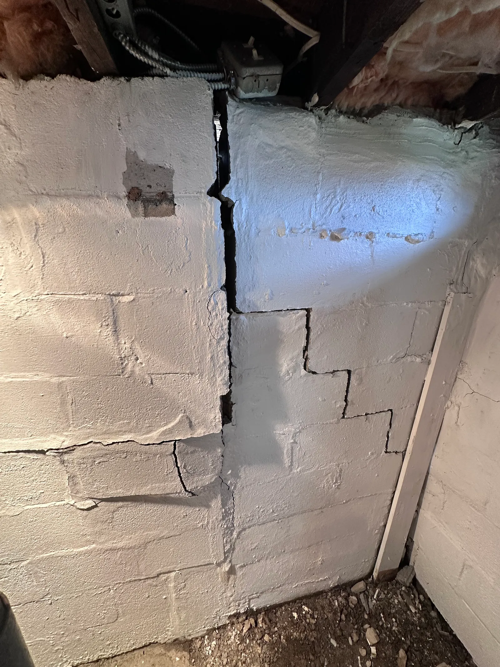 Bowed basement wall with horizontal and stair-step crack pattern in CMU block