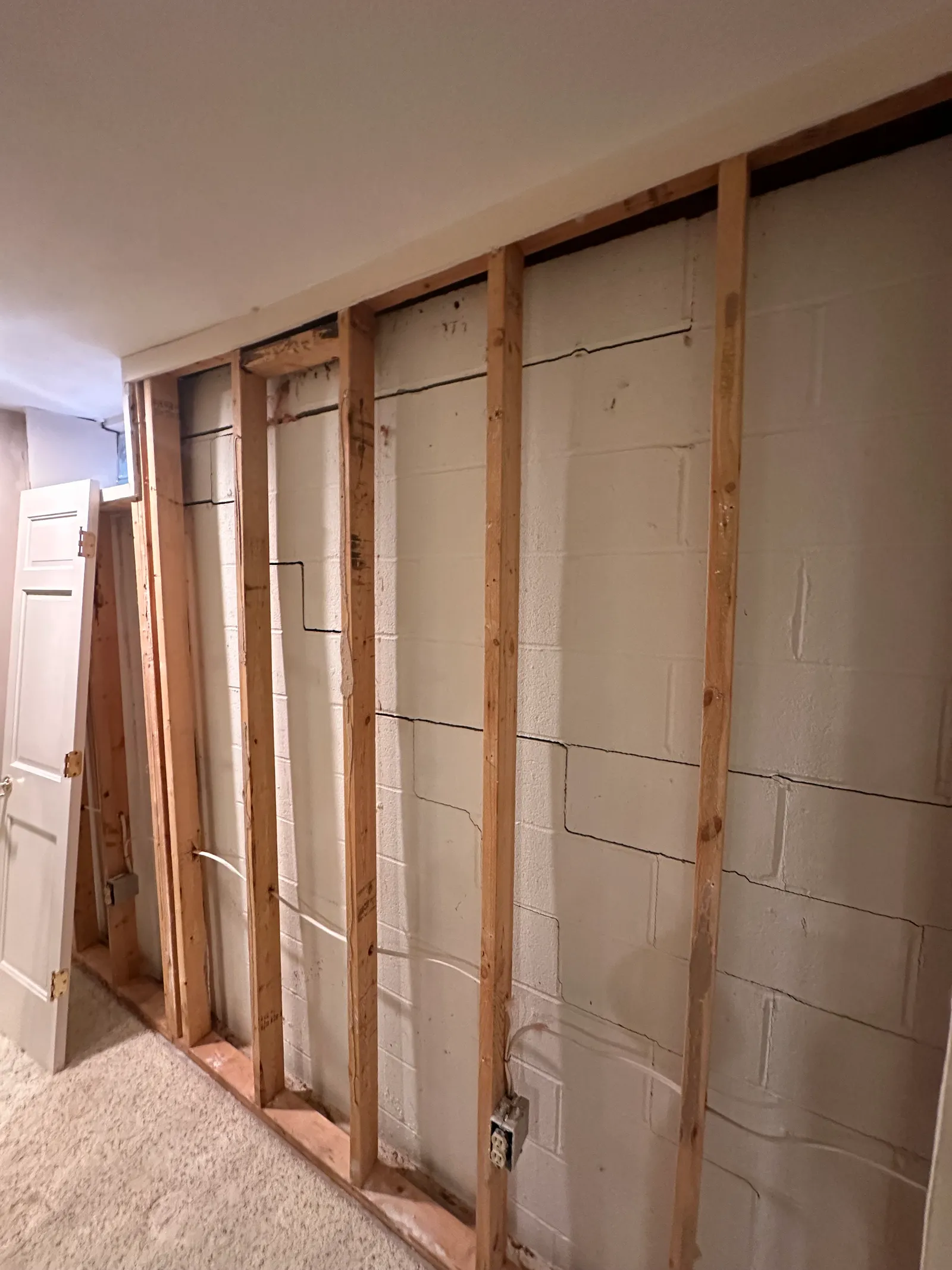 Drywall removed revealing cracked CMU block wall requiring stabilization