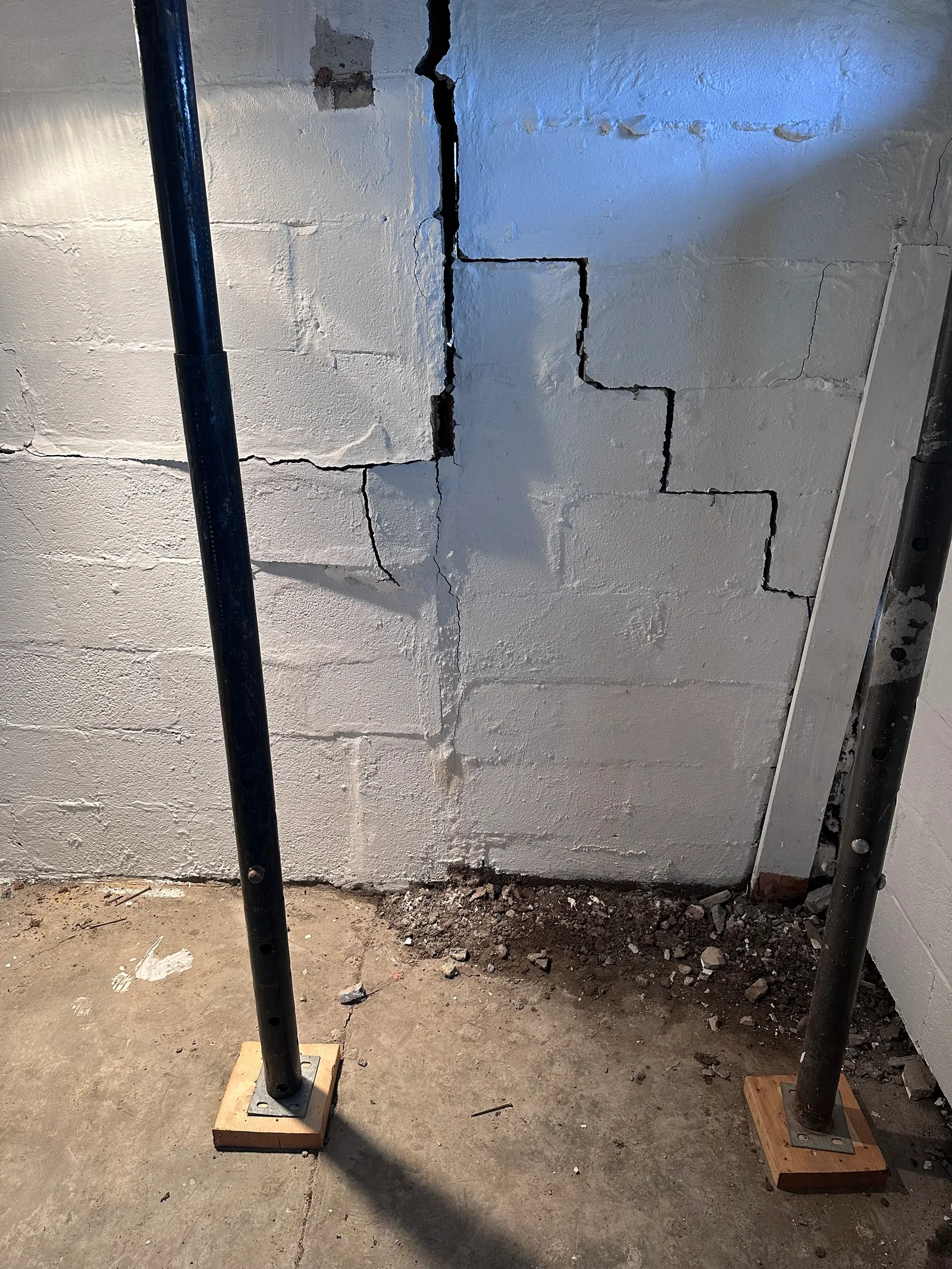 Severe stair-step cracking in basement block wall with steel stabilization brace installed